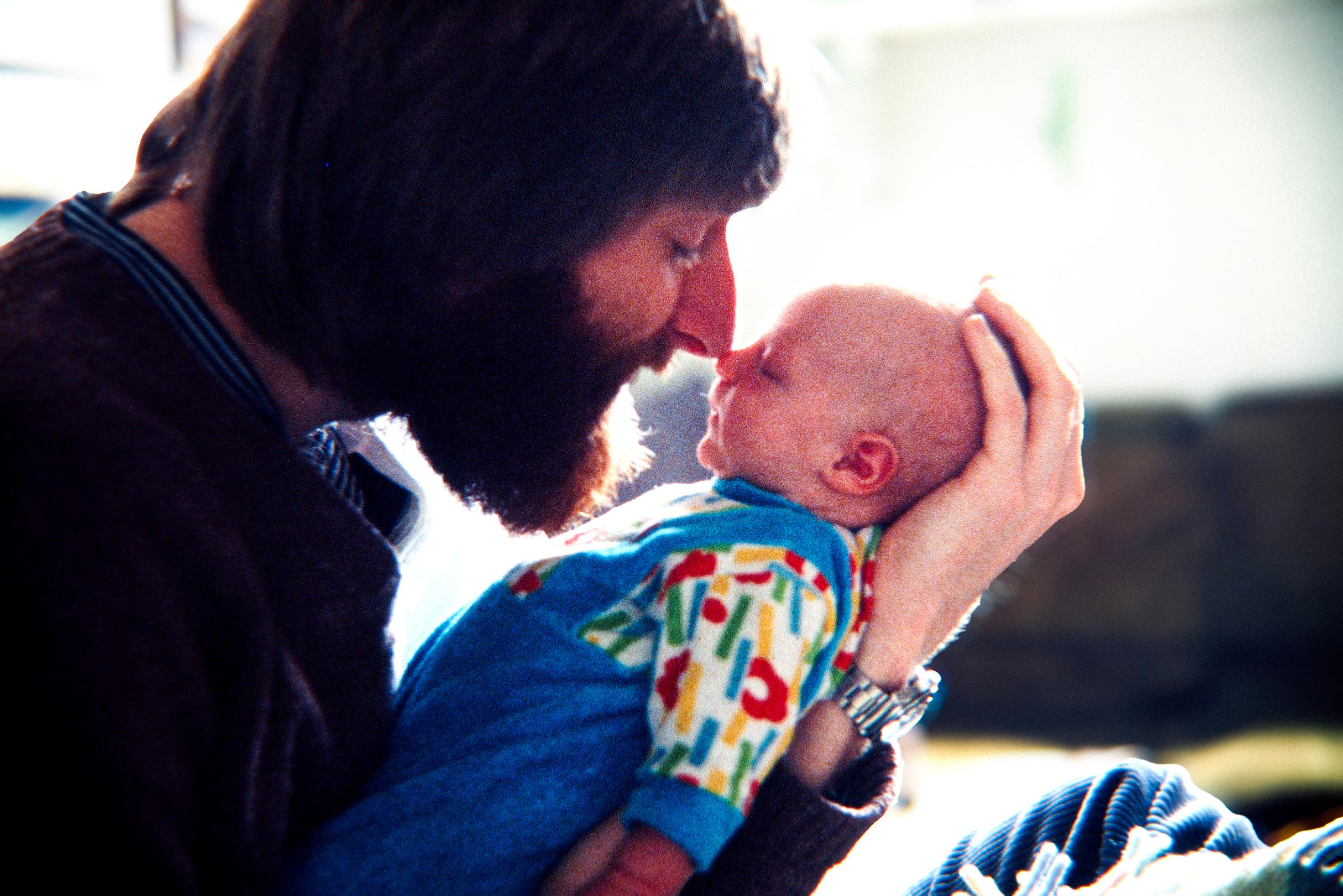 Young Peter Wirth tenderly holding his baby in a personal family moment